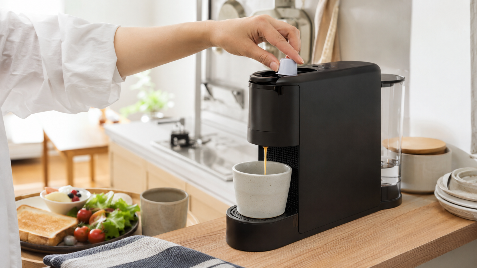 忙しい朝に省スペースのカプセル式コーヒーメーカーで1杯を淹れる様子